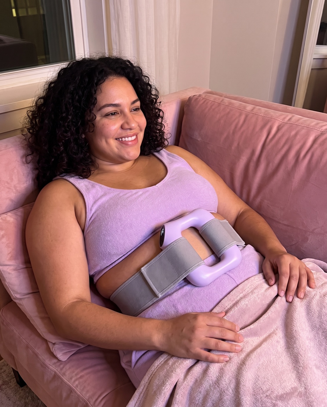 Woman relaxing on a pink sofa wearing Loop Relief